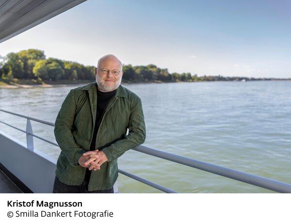 Das Foto zeigt den Autor Kristof Magnusson an einem Gel&auml;nder vor einem Gew&auml;sser. 