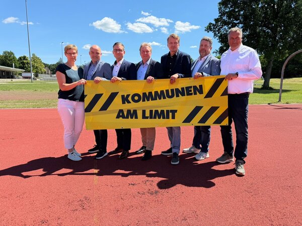 Die hauptamtlichen B&uuml;rgermeister des Kreises Herzogtum Lauenburg sowie die Amtsdirektorin des Amtes B&uuml;chen halten ein gelbes Banner mit der Aufschrift "Kommunen am Limit".