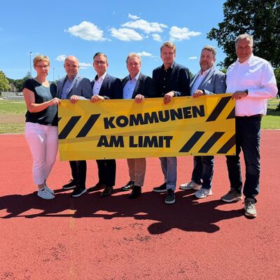 Die hauptamtlichen B&uuml;rgermeister des Kreises Herzogtum Lauenburg sowie die Amtsdirektorin des Amtes B&uuml;chen halten ein gelbes Banner mit der Aufschrift "Kommunen am Limit".