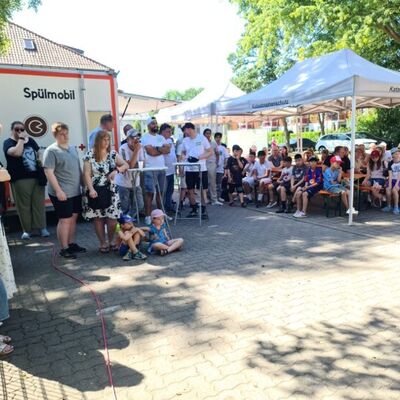 Bild vergr&ouml;&szlig;ern: G&auml;ste der Er&ouml;ffnungs- und Nachbarschaftsparty verbringen gemeinsam Zeit auf dem Gel&auml;nde des Holzhauses.