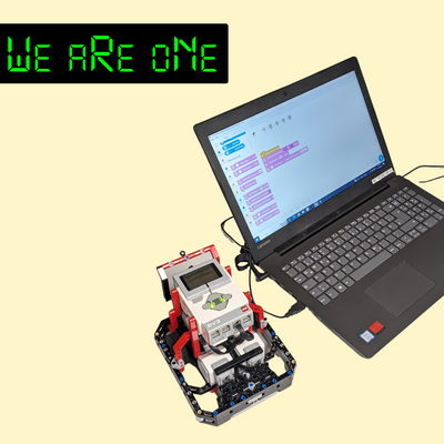 Das Bild zeigt einen Laptop, neben dem auf der linken Seite ein Lego Roboter steht. Oben links in der Ecke ist das Logo des Vereins We are one zu sehen. 